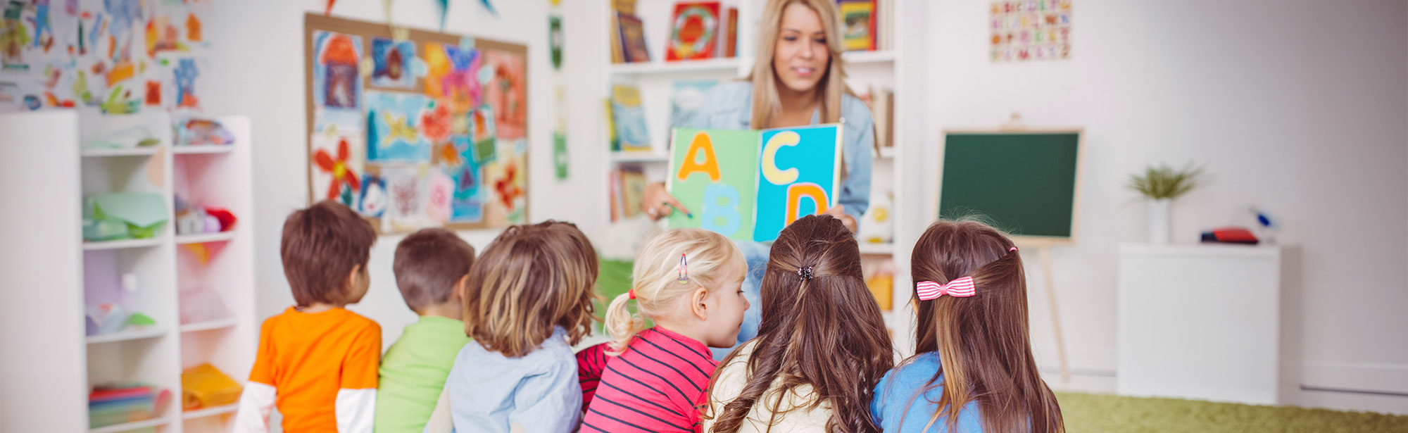 Vorschulpädagogin mit Kindern bei Lernen des Alphabets