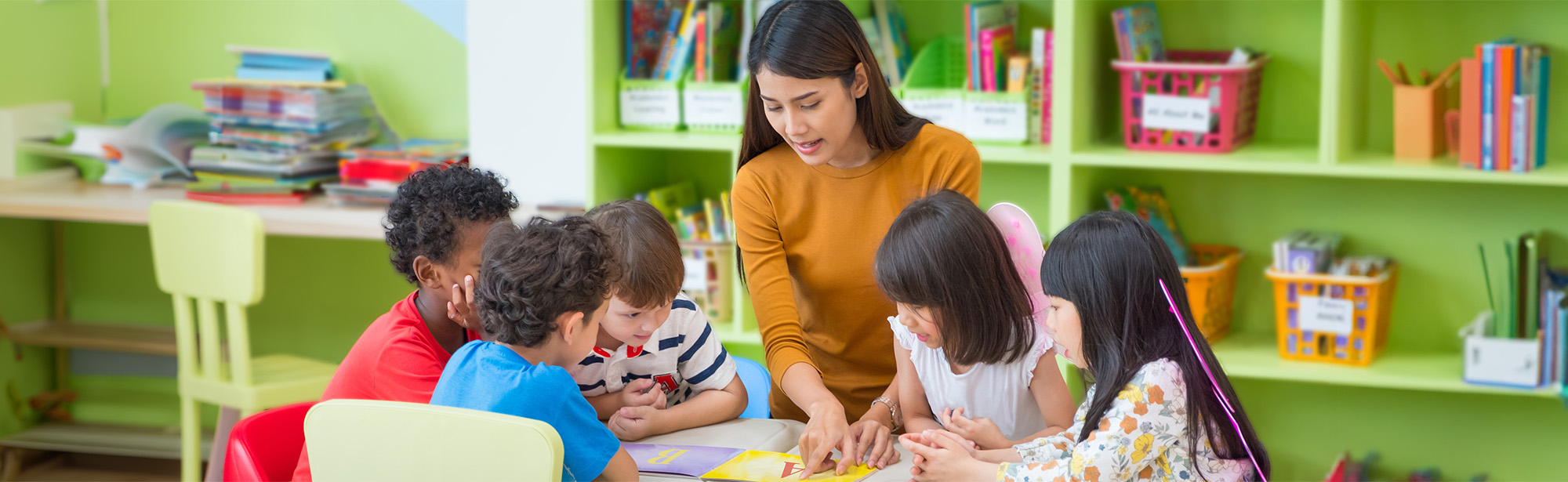 Pädagogin mit Kindern unterschiedlicher ethnischer Herkunft beim Sprachunterricht